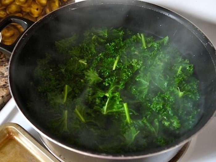 Steaming cabbage in hot water as part of the blanching process.