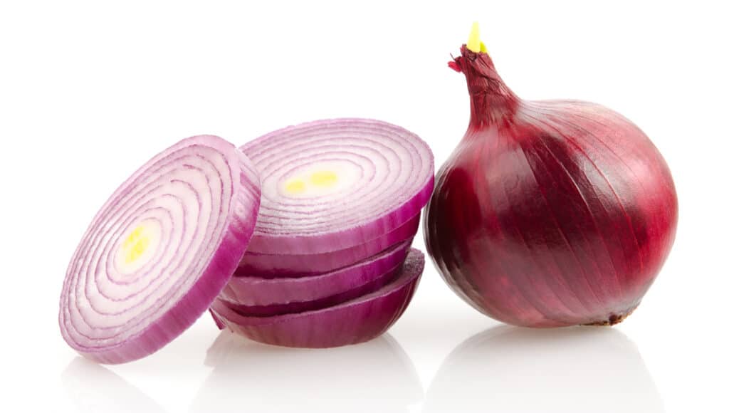 Red onion with skin cut into slices