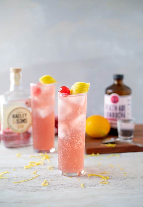 Míchaný růžový nápoj s citronem a kandovanou třešní.