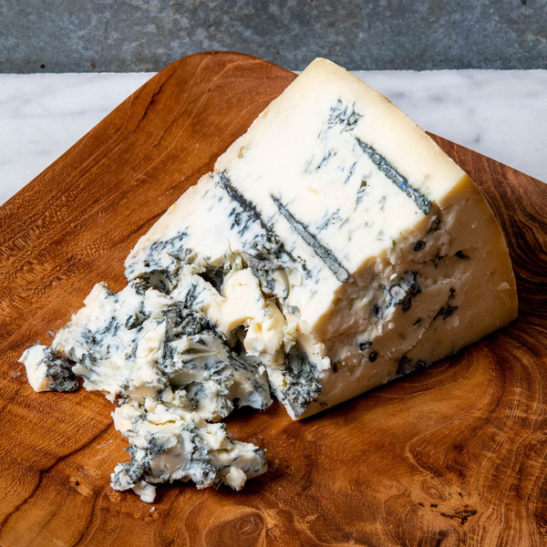 Plísňový italský sýr plný chuti položený na dřevěném prkénku.