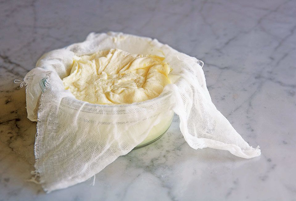 Vyrobený smetanový sýr v gáze a míse. 