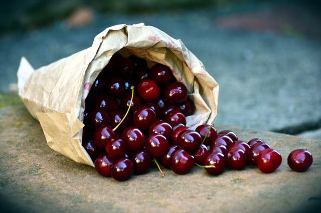 A paper bag full of cherries