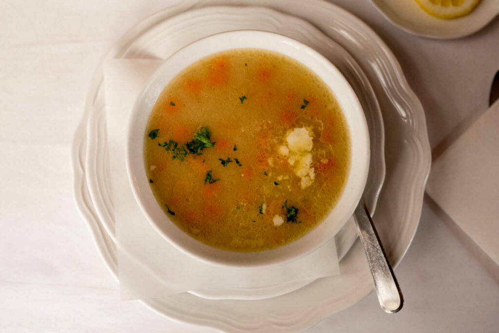 Zeleninové polévka servírovaná v mističce na talíři. 