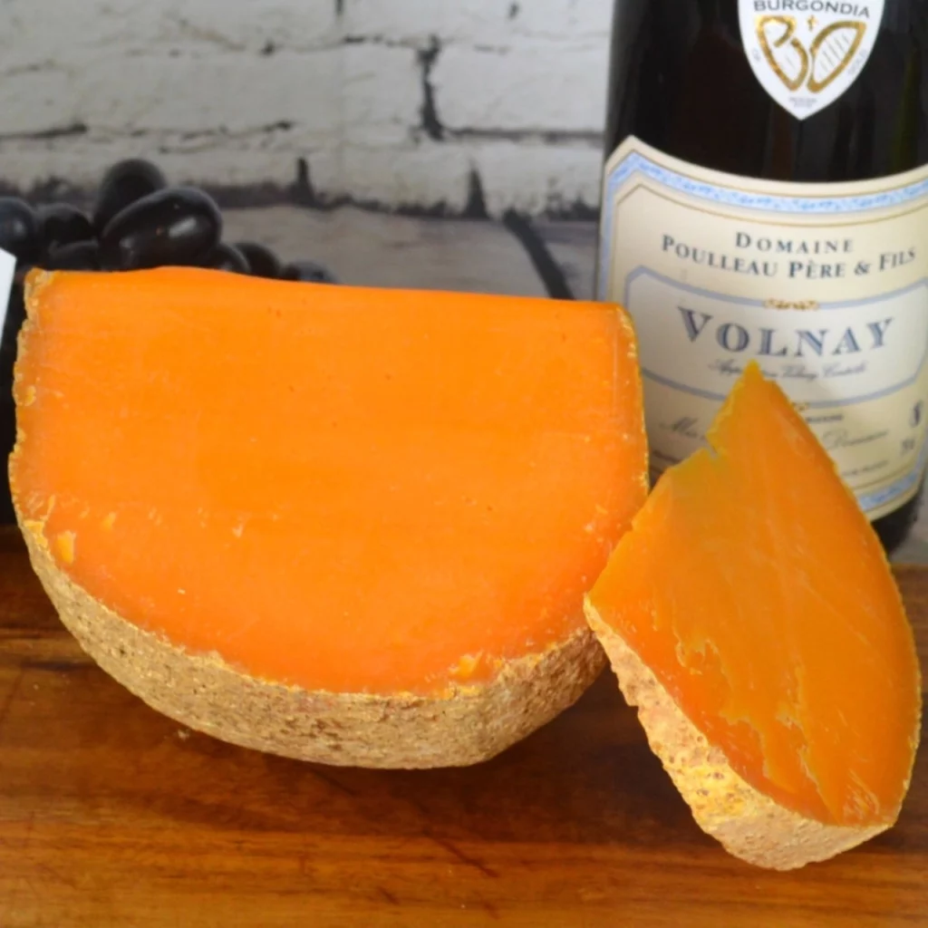 Koule oranžového sýra nakrájená na klínky.