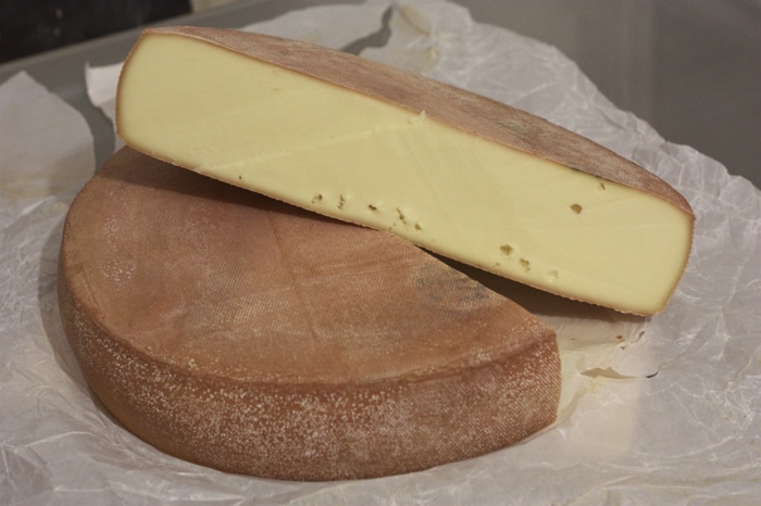 Velké sýrové kolo rozkrojené na půl. 