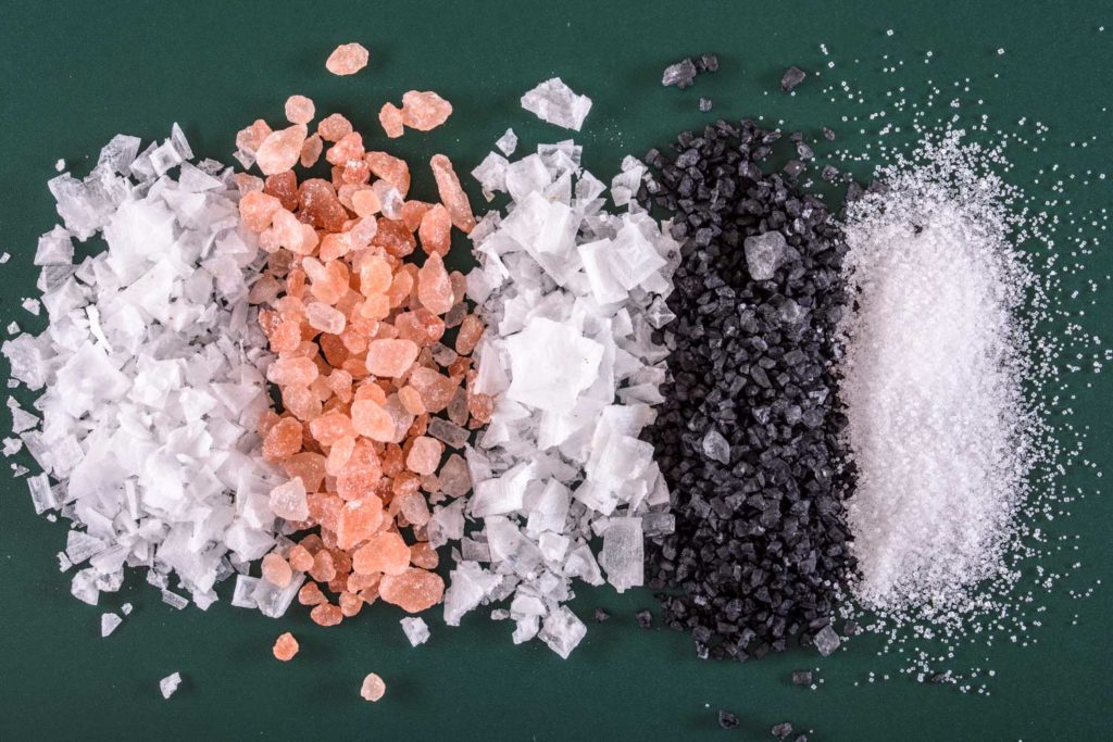 Pět různých druhů soli seřazených v lajně vedle sebe.