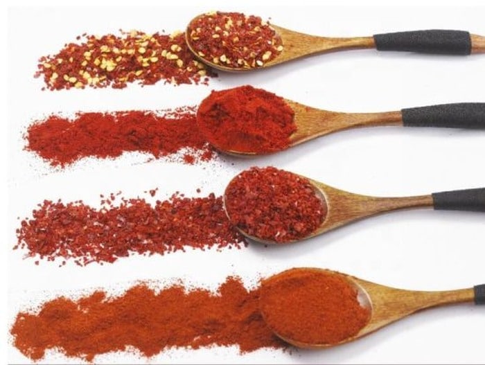Wooden spoons with different hot spices.