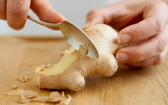 Peeling ginger root with a spoon.