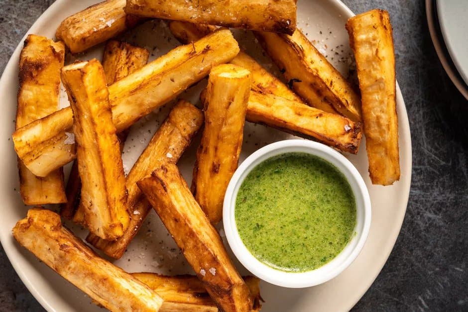 Cassava fries on a plate with a bowl of dip.