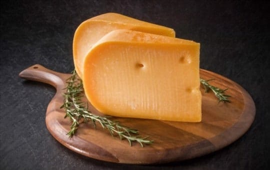 Cheddar-Käse auf ein Holzschneidebrett gelegt.