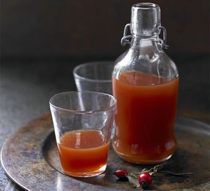 Bottle and glass with rose hip syrup.