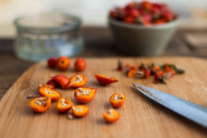 Cutting and cleaning fresh rose hips.