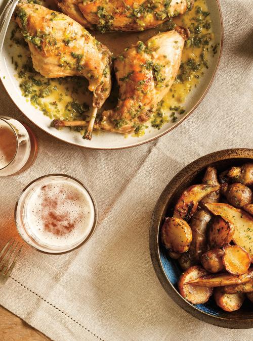 Kusy králíka dušené v omáčce z piva a javorového sirupu, servírované na talíři s vedle položenou sklenicí piva a talířem pečených brambor. 