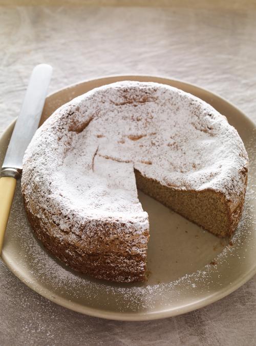 Buckwheat and chestnut cream cake, which is sliced and served on a plate with a knife.