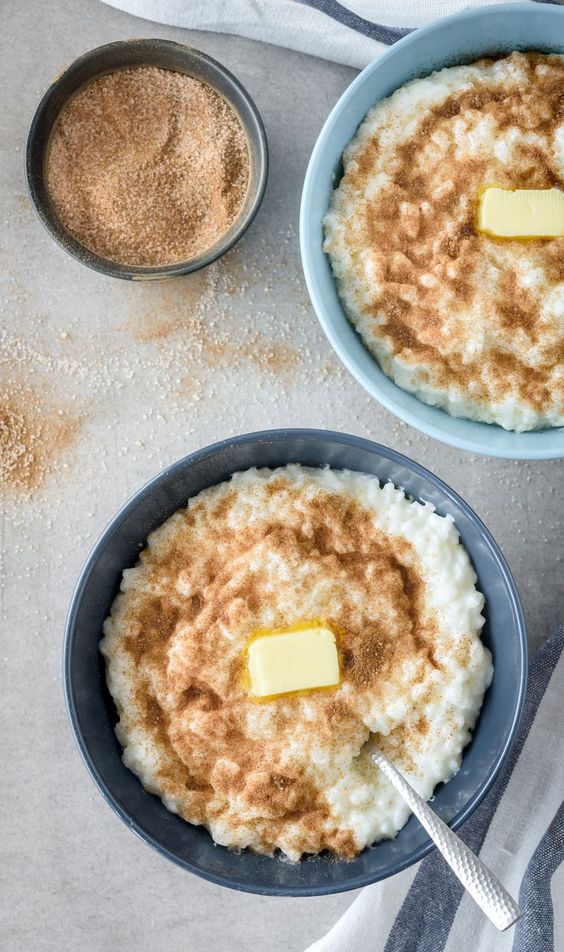 Dvě misky plné uvařené rýže se skořicovým cukrem a máslem.