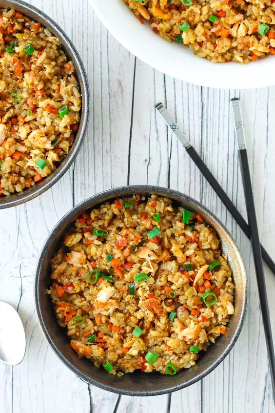 A bowl full of fried rice with vegetables and egg.