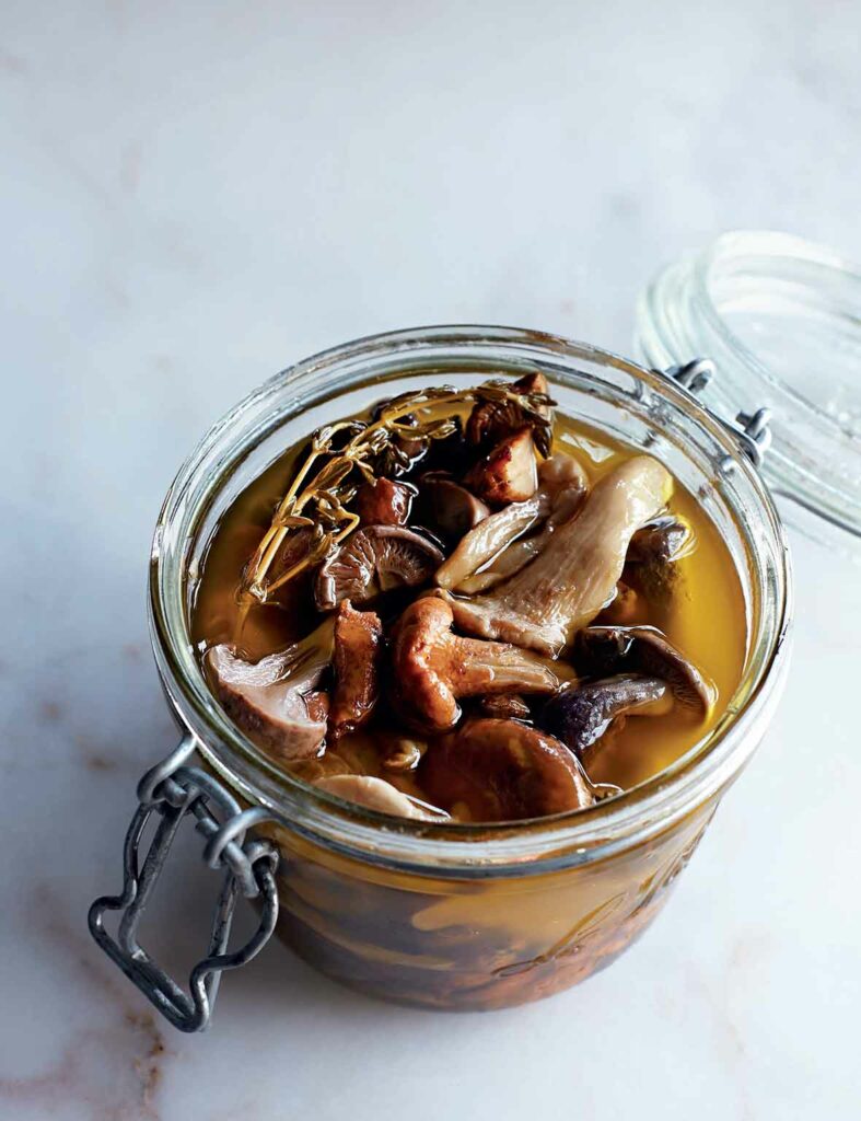 Pickled mushrooms in an open jar.