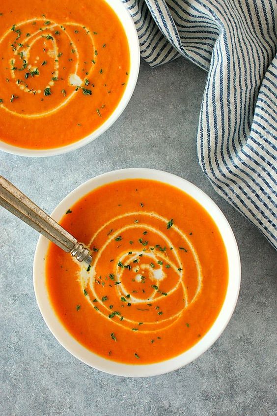 Sytě oranžové polévka z čerstvé sladké mrkve a smetanou.