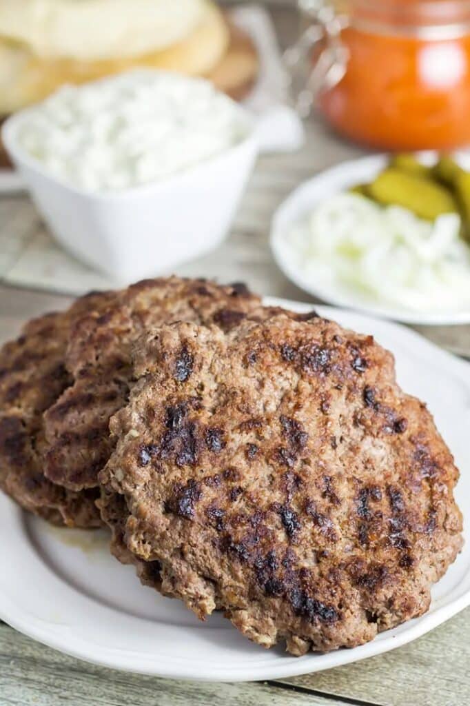 Traditional Serbian burger in pita bread with onions, cucumbers and ajvar.