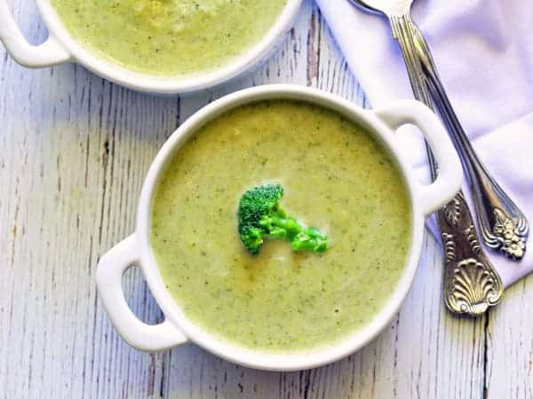 Polévka z brokolice servírovaná v miskách a ozdobená růžičkou brokolice.