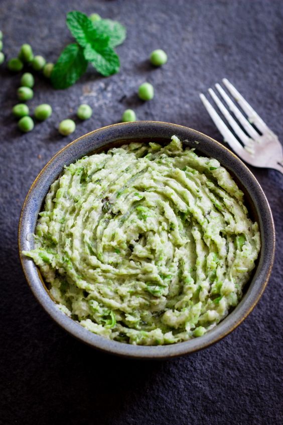 A bowl full of pea mash with pieces of peas.