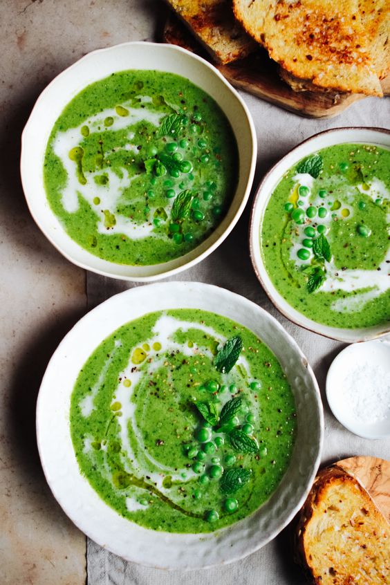 White bowls full of delicious creamy soup with peas.