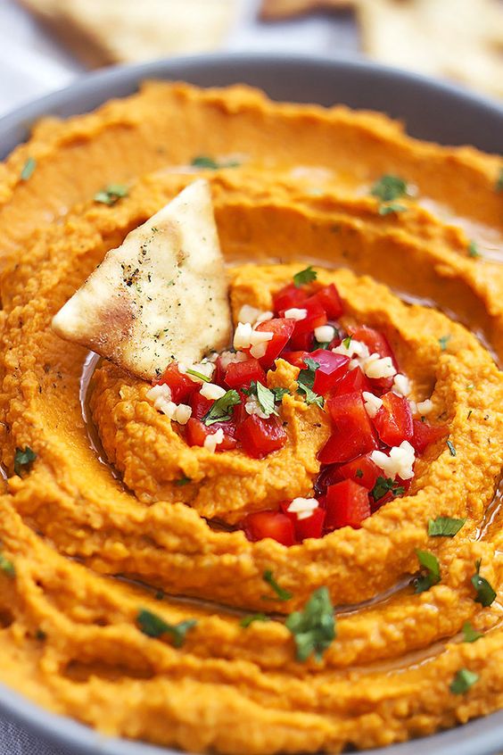 Hummus with red pepper and salty chips.