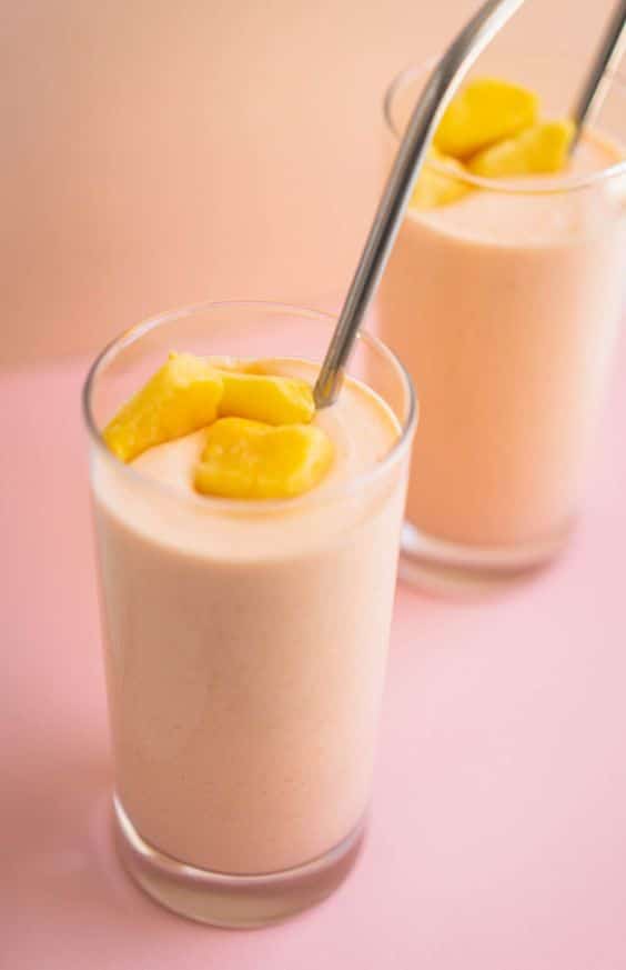 A glass full of creamy mango and carrot smoothie.