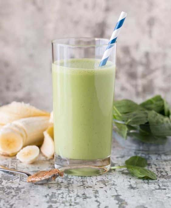 A glass of mixed spinach, banana and butter.
