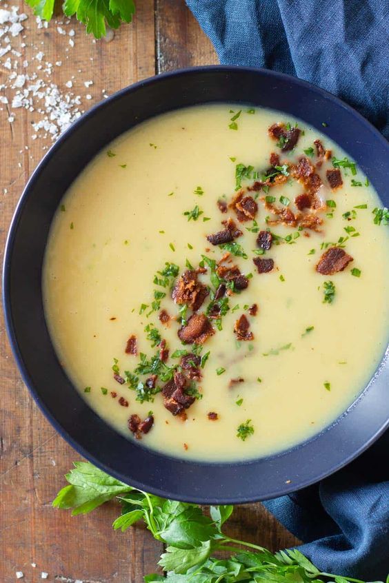 A plate full of delicious soup with fried bacon.