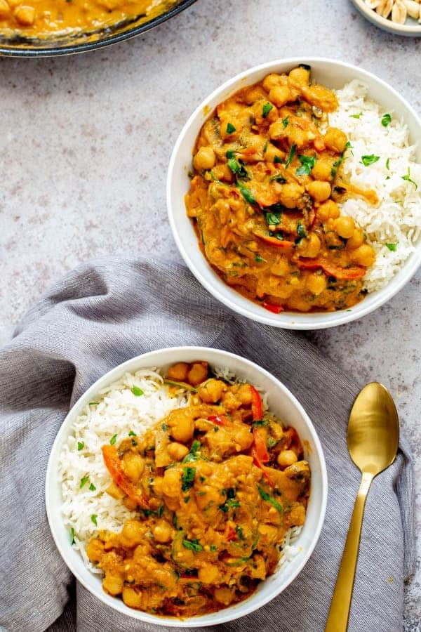 Curry with chickpeas and vegetables served in bowls with rice.