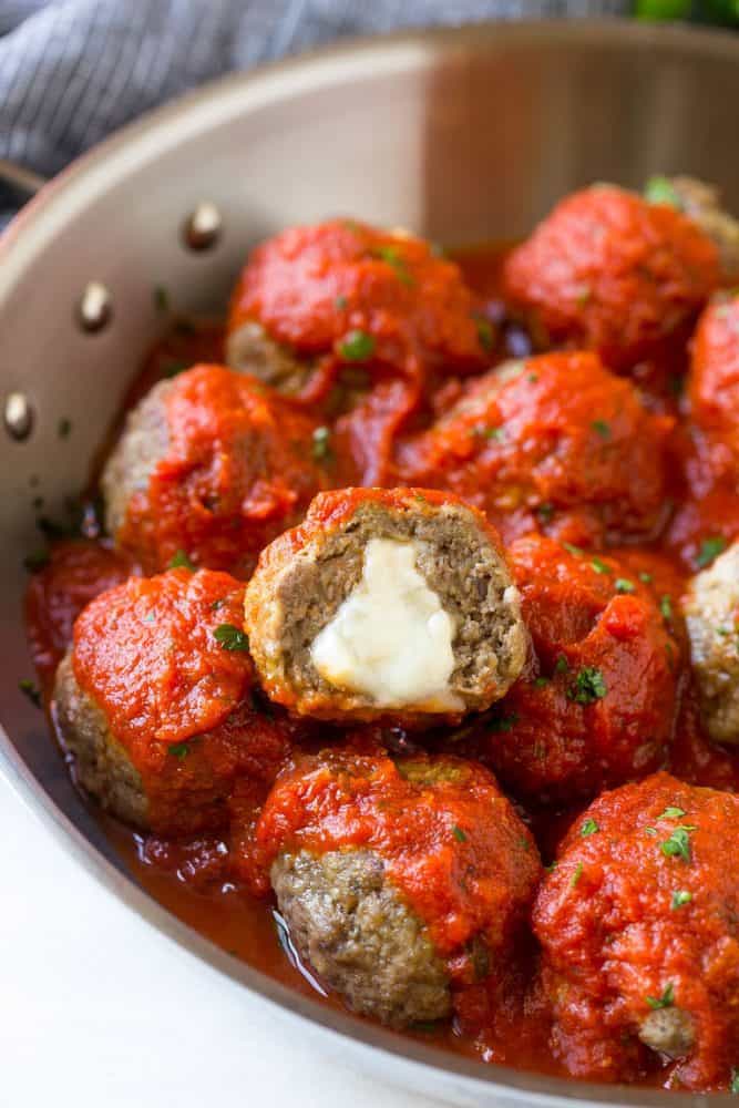 Minced meatballs filled with cheese, covered in tomato sauce and served in a pan.