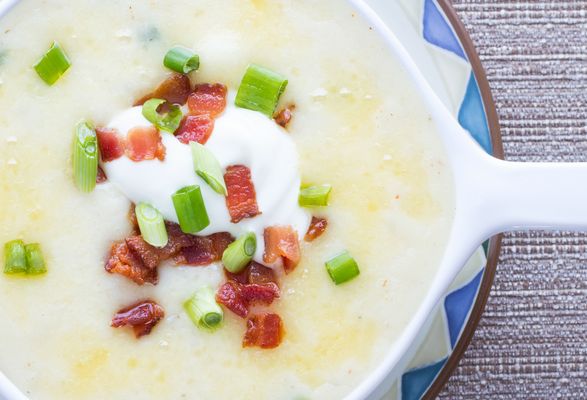 Soup with cottage cheese garnished with chopped bacon and spring onion.
