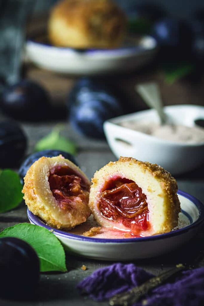 Halved dumpling filled with plum on a plate.