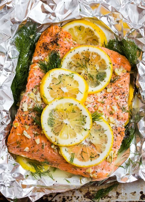 Grilled salmon in foil with lemon slices and fresh dill.