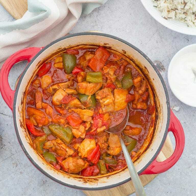 Chicken stew with vegetables in a pot with a spoon.