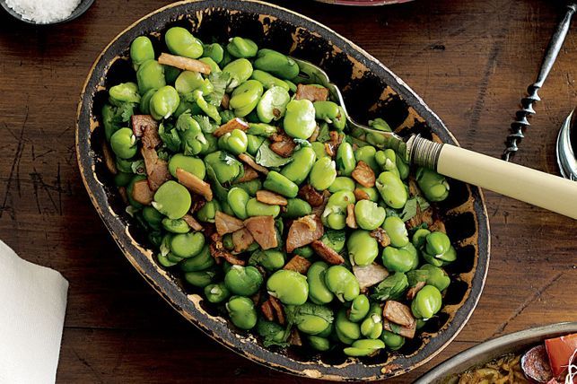 Roasted broad beans with bacon and garlic in a bowl.