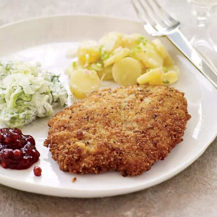 Potato cutlets on a plate with coleslaw, boiled potatoes and cranberry jam.