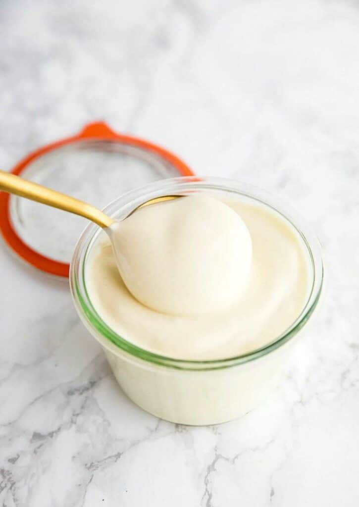 Mayonnaise for vegans in a bowl, scooped with a spoon.