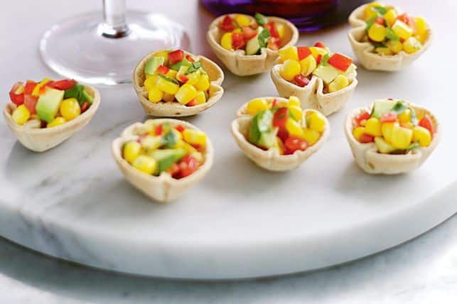 Tortilla cups filled with corn, avocado, tomatoes and cilantro.
