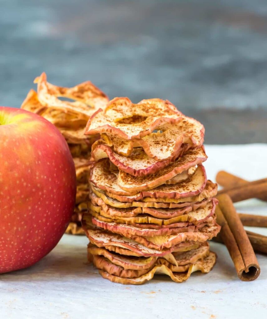 Apple chips stacked on top of each other and sprinkled with cinnamon.