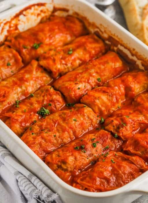 Tender cabbage leaves stuffed with a mixture of minced meat and rice, baked with a simple tomato sauce, in a baking dish.