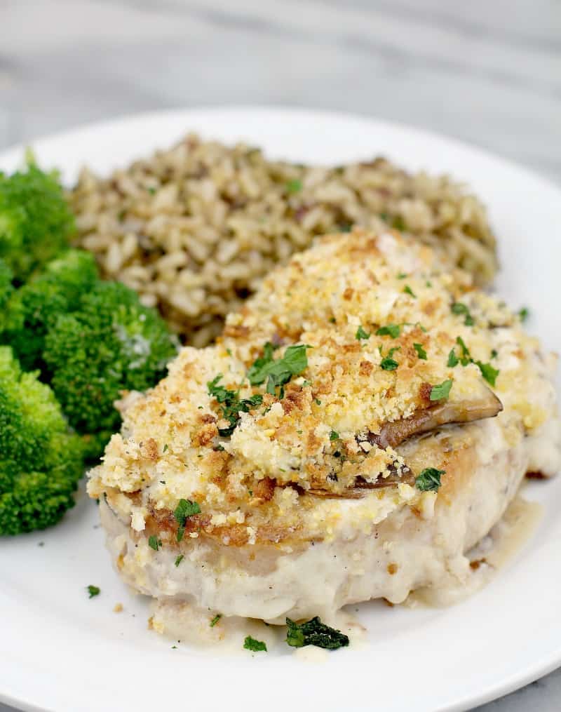 Baked pork with mushroom sauce served on a plate with broccoli.