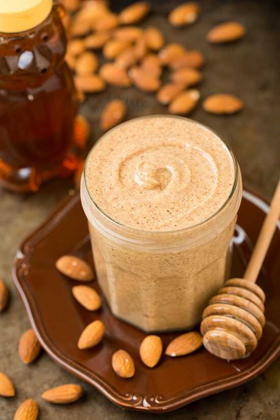 Almond butter in a glass that is placed on a plate.
