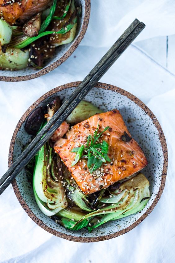 A stone bowl full of delicious pak choi salad with seared salmon.