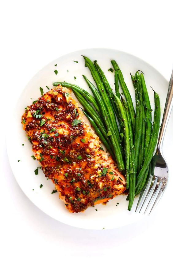 A plate full of perfectly cooked salmon in the oven with a sweet and spicy sauce.