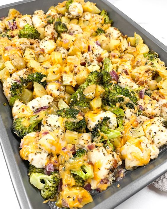 A tray filled with an excellent combination of broccoli, potatoes, cheese and chicken.