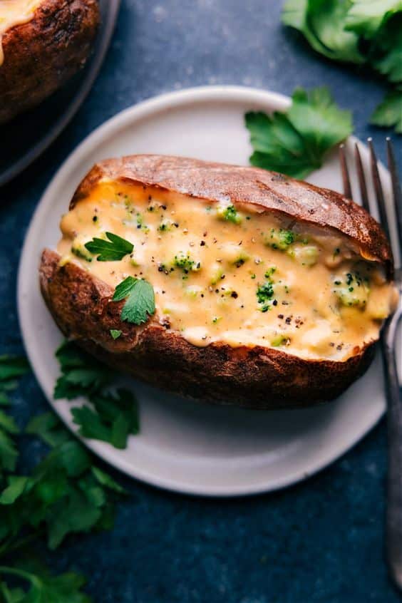 Upečený rozpolený zemiak naplnený zmesou syra a brokolice.