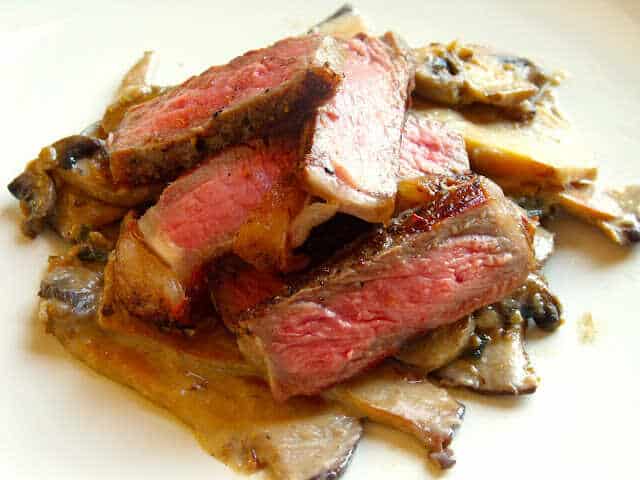 Grilované steaky z hovězího roštěnce servírované spolu s omáčkou ze žampionů a hlívy ústřičné.