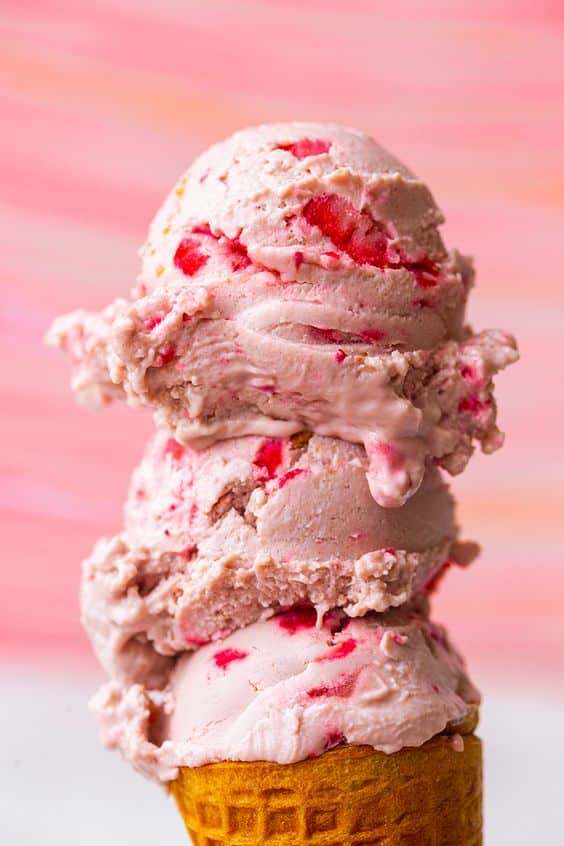 Kornout naplněný třemi kopečky růžové zmrzliny.